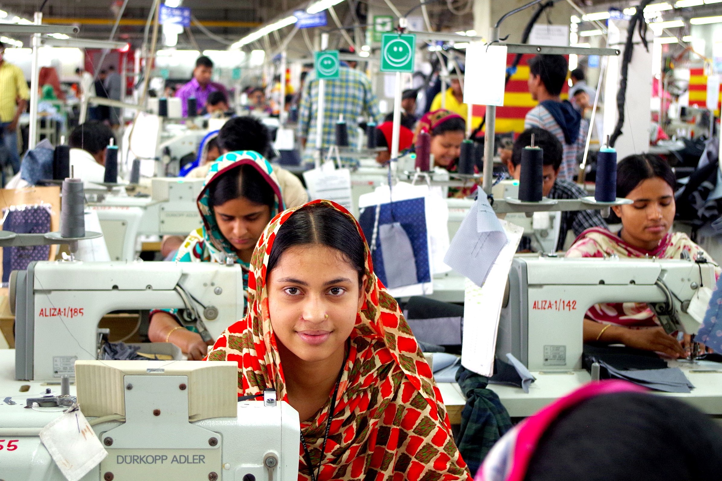 Garment workers sewing in close quarters in factory
