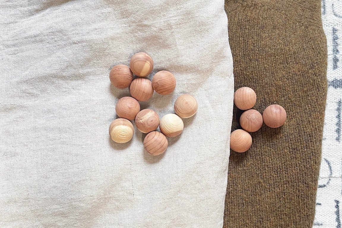 cedar balls lying on linen and knit garments