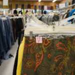 Racks of jeans and skirts at a thrift store