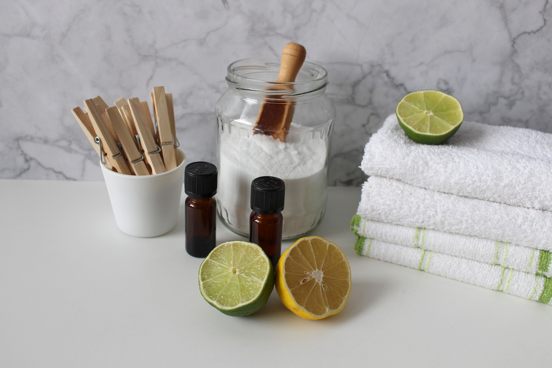 Glass jar of laundry powder with essential oils and bowl of clothes pins