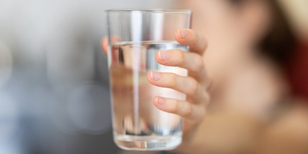 human hand holding a glass of water