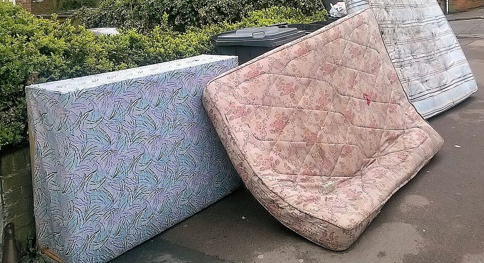discarded used mattresses on side of road