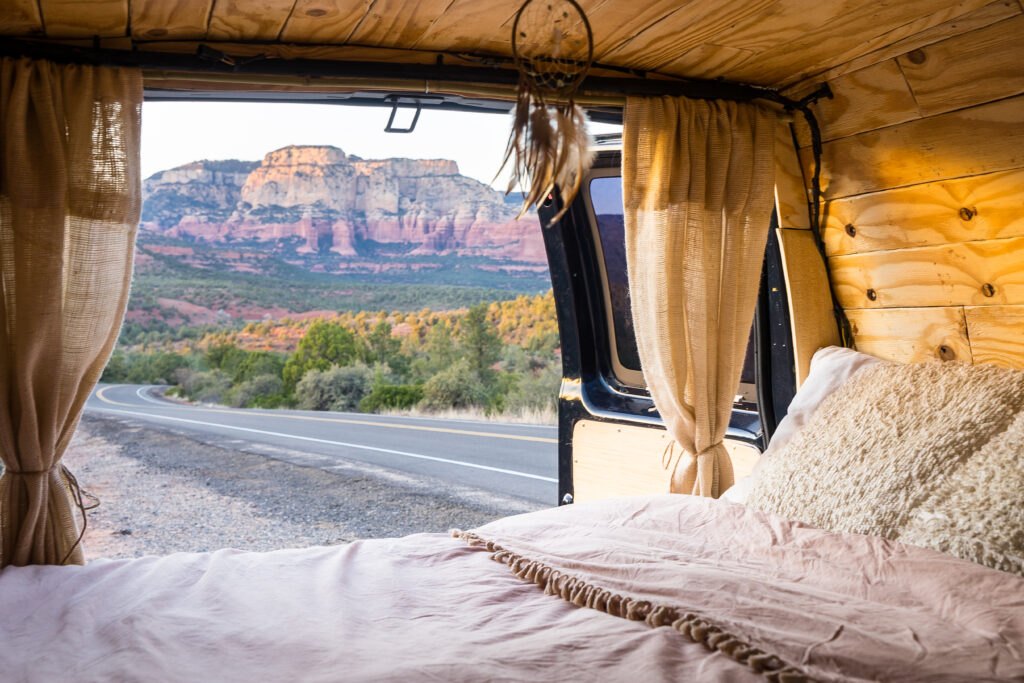 bed inside a van with mountains in background