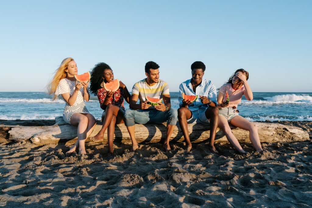 friends eating watermelon at the beach