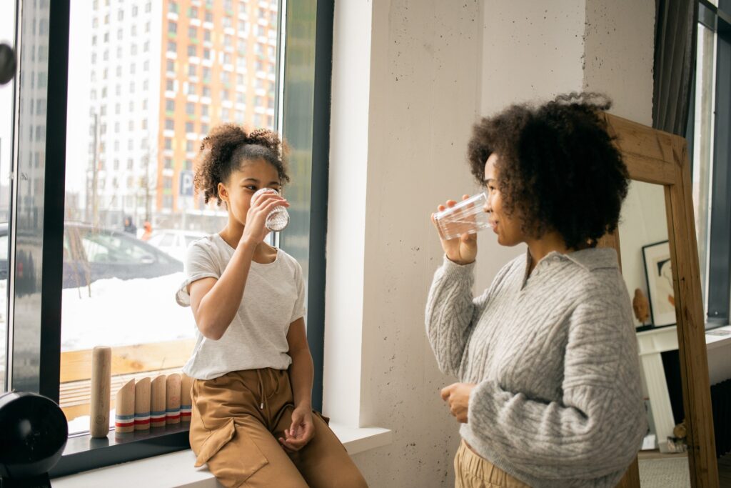 woman and daughter drinking glasses of water