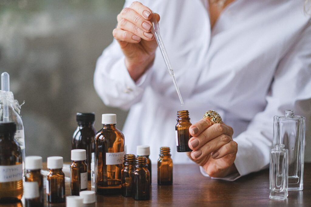 person making fragrance with glass bottles and a lab coat